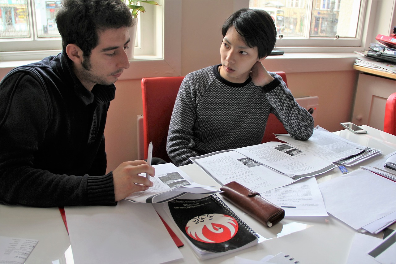 teachers sitting at a table doing planning with lots of papers