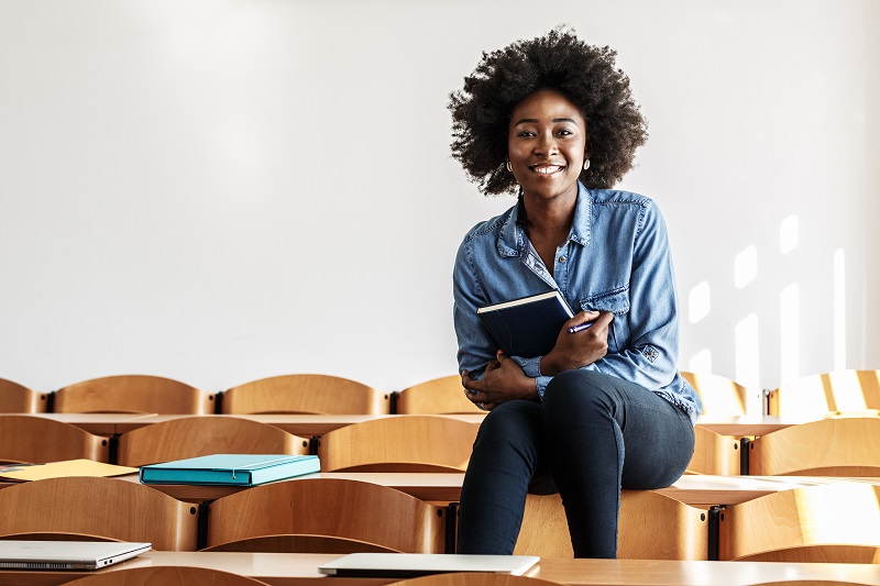 A teacher sitting on a desk in her classroom